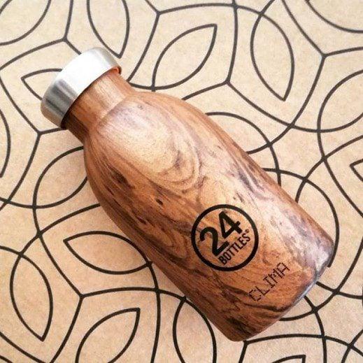 Reusable insulated bottle with wood grain design and steel cap on geometric background